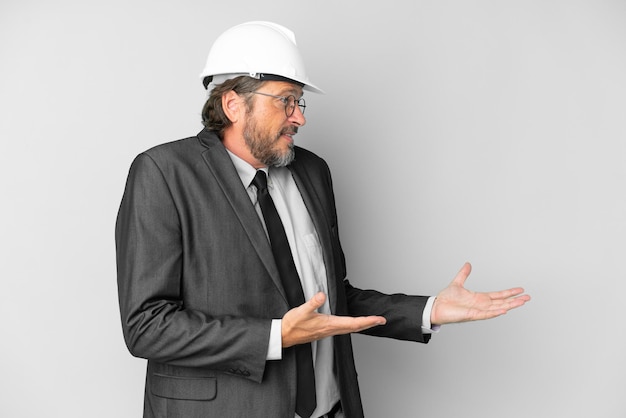 Young architect man with helmet over isolated background with surprise facial expression