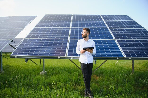 Young architect standing by solar panels