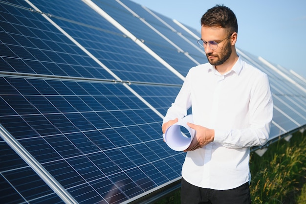 Young architect standing by solar panels