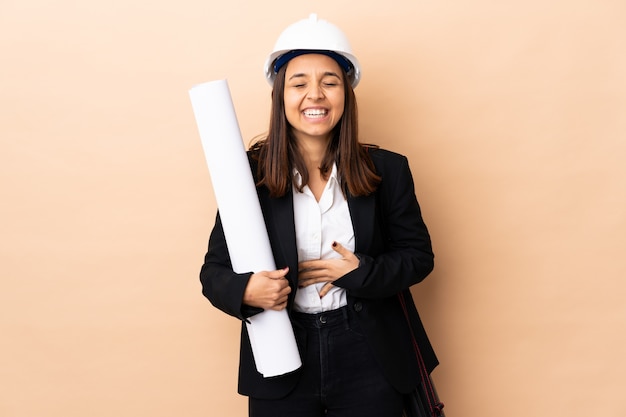 Photo young architect woman holding blueprints over isolated smiling a lot