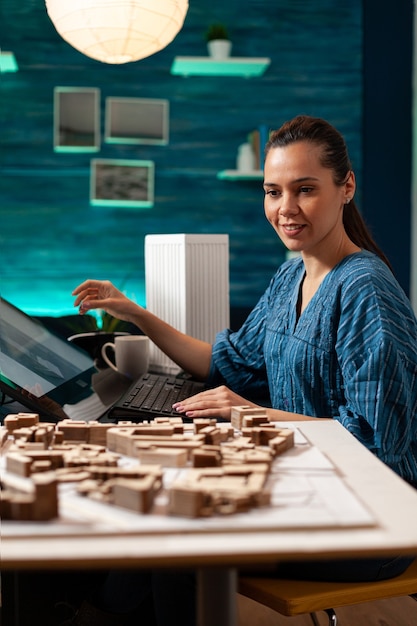 Foto giovane architetto che lavora alla costruzione di una maquette in miniatura