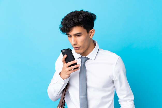 Young Argentinian businessman over isolated blue wall