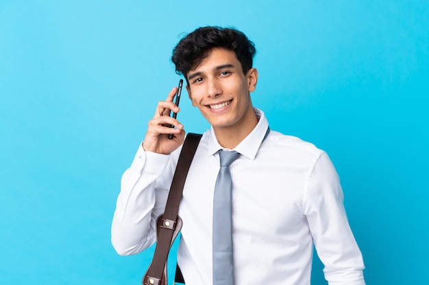 Young Argentinian businessman over isolated blue wall