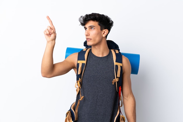 Young Argentinian hiker man over isolated white wall touching 