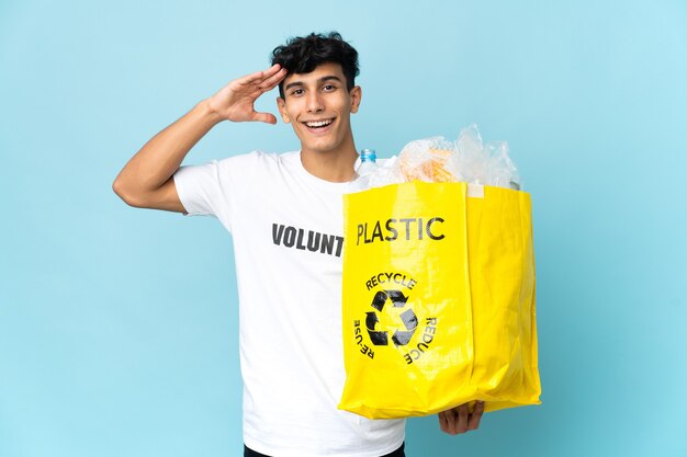 Young Argentinian man holding a bag full of plastic with surprise expression