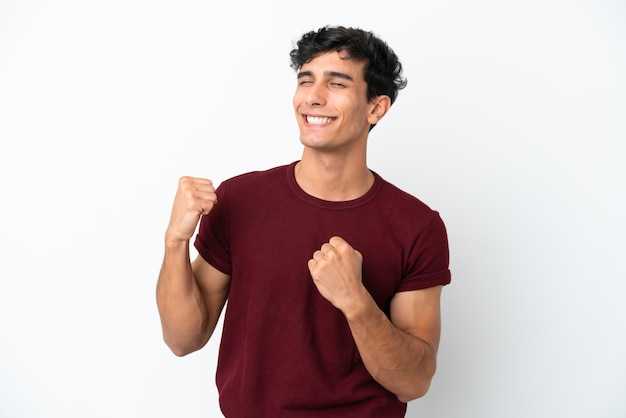 Young Argentinian man isolated on white background celebrating a victory