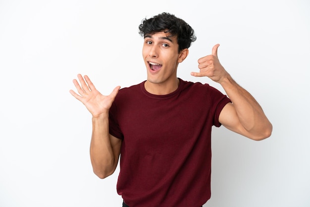 Young Argentinian man isolated on white background making phone gesture and doubting