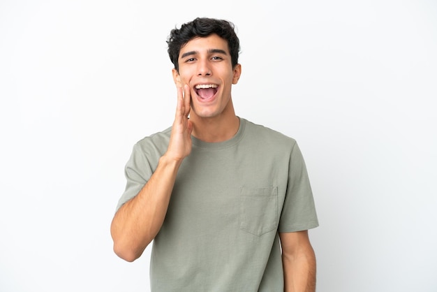 Young Argentinian man isolated on white background shouting with mouth wide open