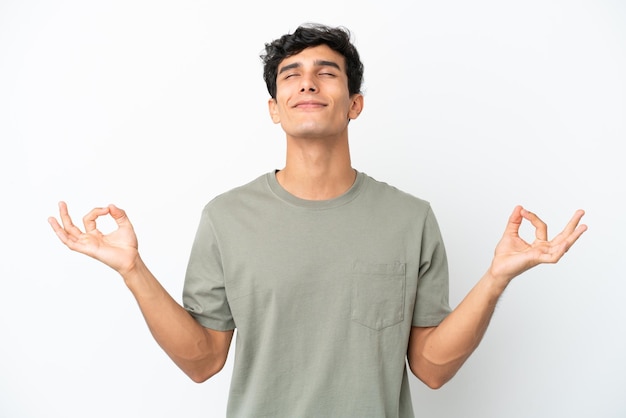 Young Argentinian man isolated on white background in zen pose