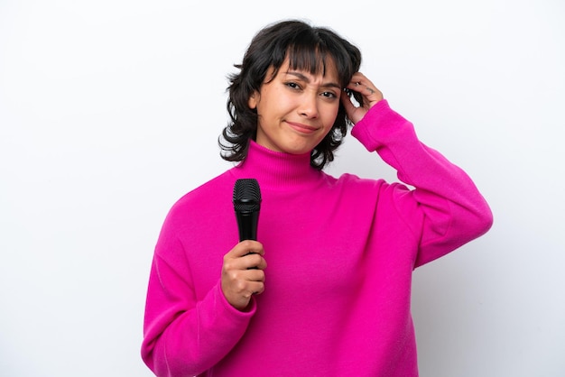 Young Argentinian singer woman isolated on white background having doubts