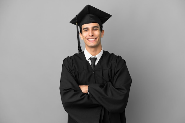 Young Argentinian university graduate isolated on grey background keeping the arms crossed in frontal position