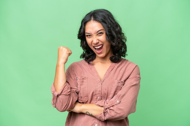 Young argentinian woman over isolated background celebrating a victory