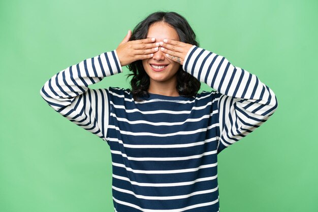 Young Argentinian woman over isolated background covering eyes by hands