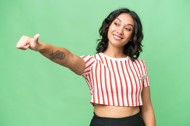 Young Argentinian woman over isolated background giving a thumbs up gesture