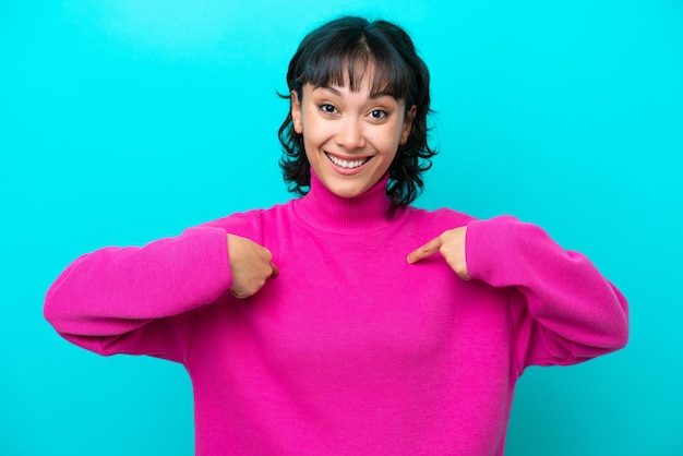 Young Argentinian woman isolated on blue background with surprise facial expression