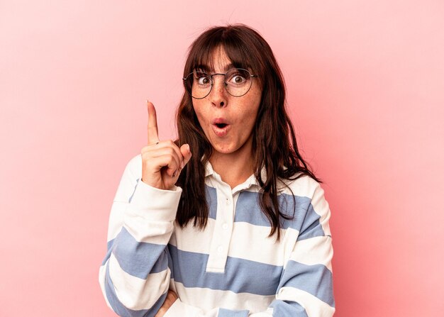 Young Argentinian woman isolated on pink background having an idea, inspiration concept.