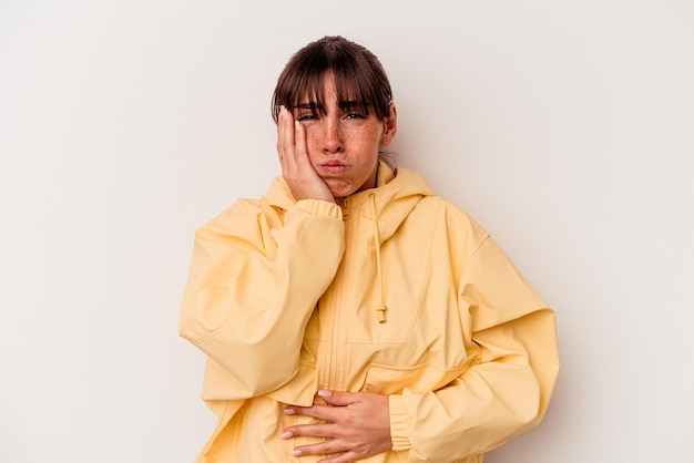 Young Argentinian woman isolated on white background blows cheeks, has tired expression. Facial expression concept.