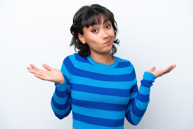 Young Argentinian woman isolated on white background having doubts while raising hands