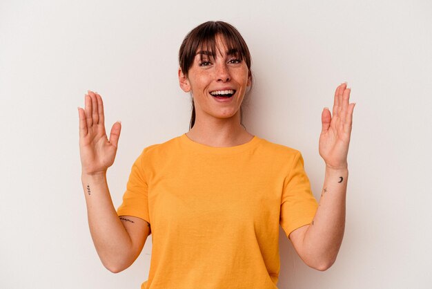 Young Argentinian woman isolated on white background holding something little with forefingers, smiling and confident.