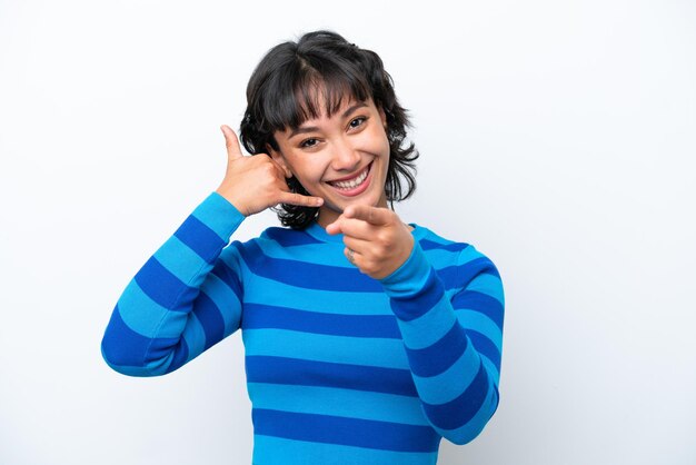 Young Argentinian woman isolated on white background making phone gesture and pointing front