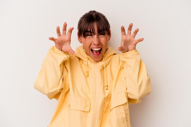 Young Argentinian woman isolated on white background showing claws imitating a cat, aggressive gesture.