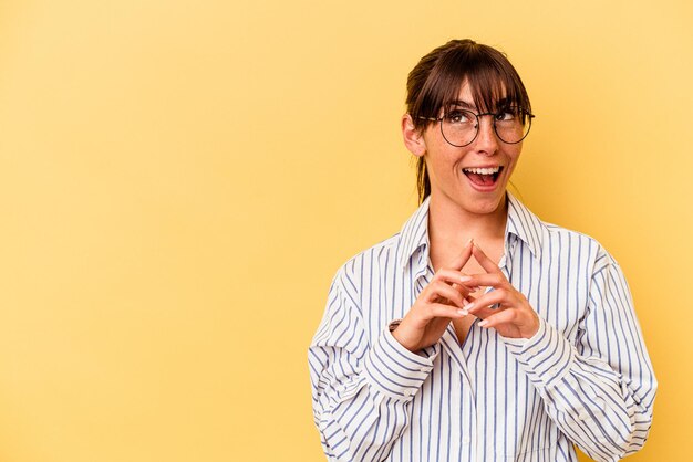 Young Argentinian woman isolated on yellow background making up plan in mind, setting up an idea.