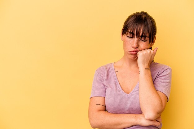 Young Argentinian woman isolated on yellow background who feels sad and pensive looking at copy space