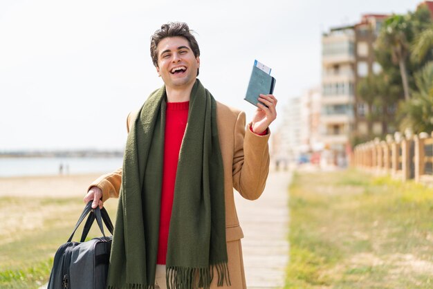 Young artist caucasian man holding a palette isolated on red background smiling a lot