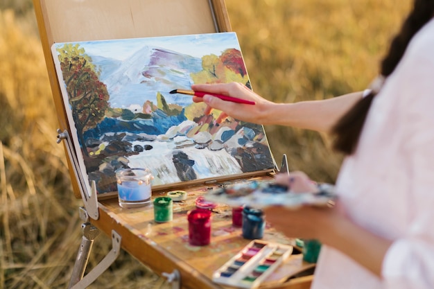 Photo young artist hand painting in the nature