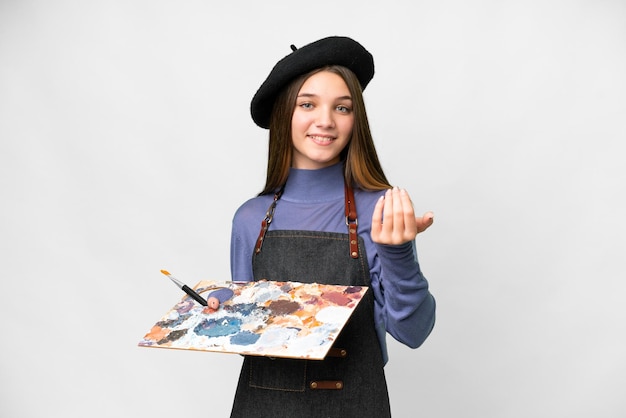 Young artist man holding a palette over isolated white background inviting to come with hand Happy that you came