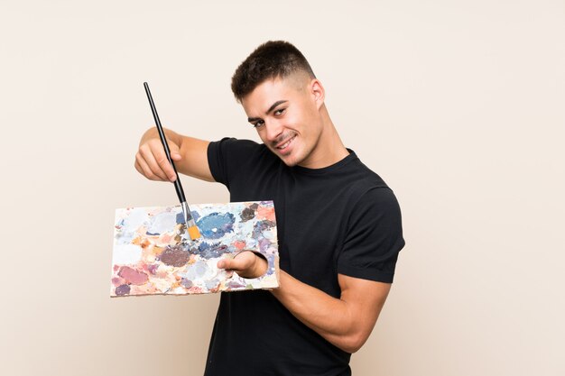 Young artist man over isolated wall