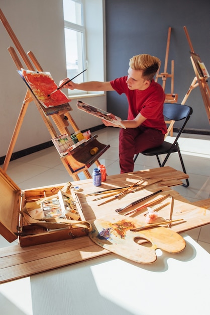 Young artist paints a picture in the studio