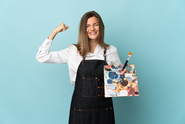 Young artist Slovak woman isolated on blue background doing strong gesture