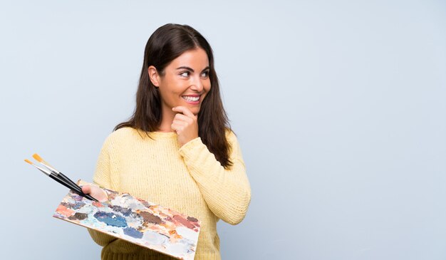 Young artist woman blue thinking an idea and looking side