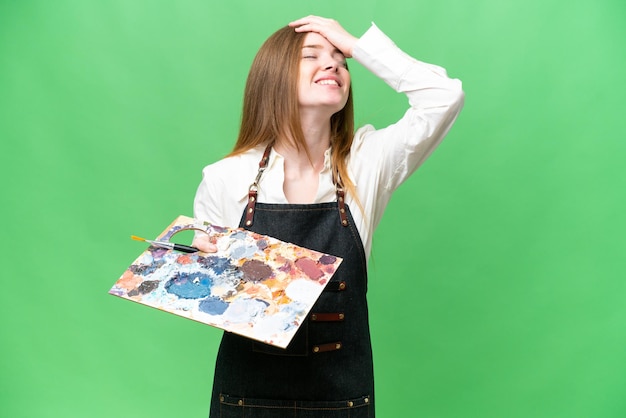 Young artist woman holding a palette over isolated chroma key background smiling a lot