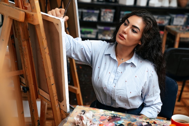 Young artist working on a painting at the studio