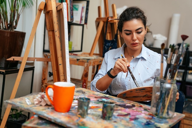 Young artist working on a painting at the studio