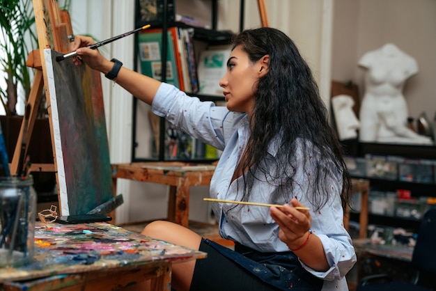 Young artist working on a painting at the studio