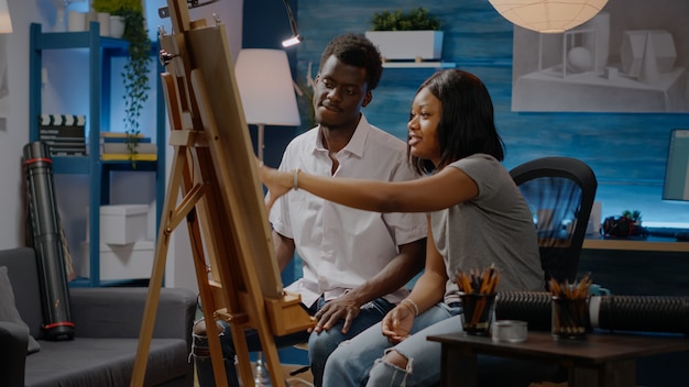 Young artists of african american ethnicity drawing on canvas