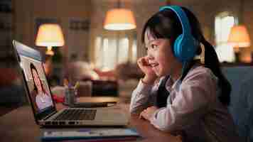 Photo young asia teen girl student wears headphones distance learning lesson with online teacher on lapto