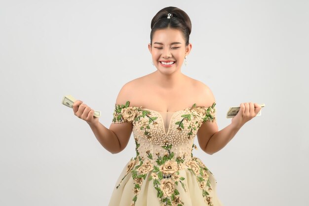 Foto giovane splendida sposa asiatica con banconote in mano