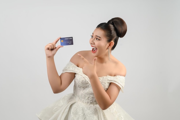 Photo young asian beautiful bride posting with credit card in hand