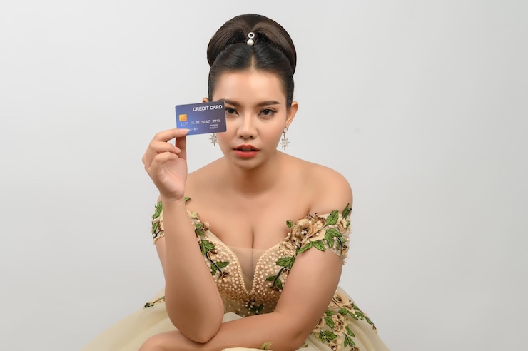 Photo young asian beautiful bride posting with credit card in hand