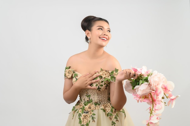 Young asian beautiful bride with orchid bouquet on white background