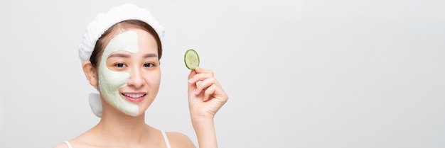 Young asian beautiful woman holding fresh cucumbers white mask cosmetic on face banner wide