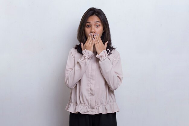 Young asian beautiful woman shocked covering mouth with hands for mistake on white background