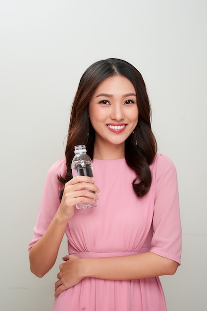 물 잔을 보여주는 젊은 아시아 아름 다운 여자.