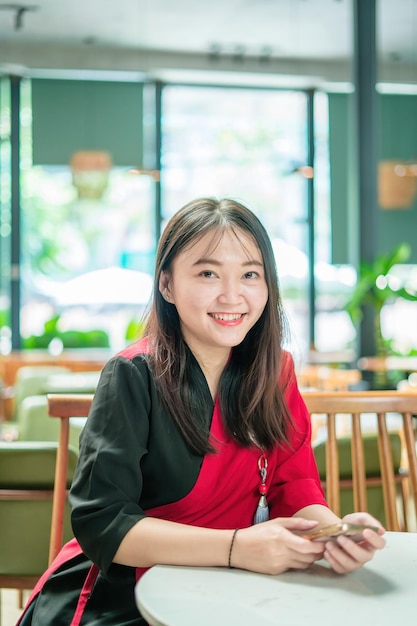 비즈니스 온라인 쇼핑 송금을 위해 스마트 폰을 사용하는 젊은 아시아 아름다운 여성