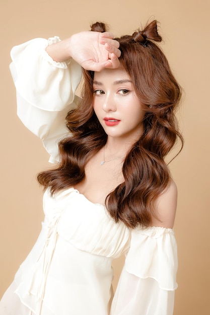 Young asian beauty woman curly long hair with korean makeup style on cute face and perfect skin on isolated beige background facial treatment cosmetology plastic surgery