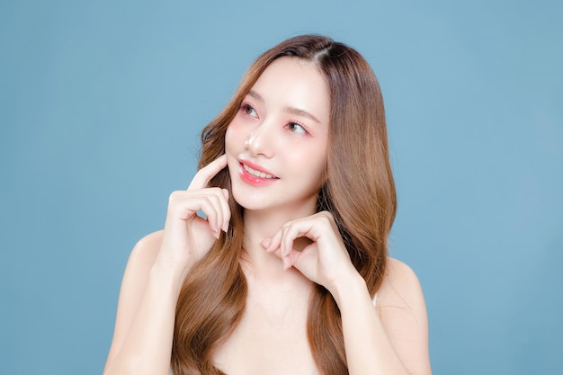 Young Asian beauty woman curly long hair with korean makeup style on face and perfect clean skin on isolated blue background Facial treatment Cosmetology plastic surgery